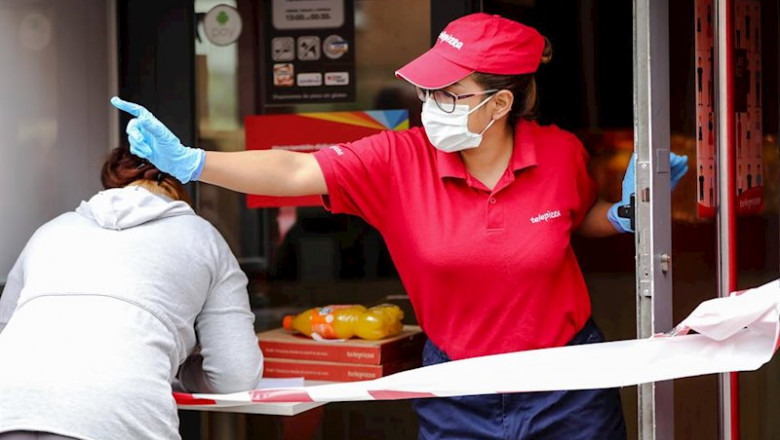 Una mujer recoge un menú infantil de Telepizza. | Jesús Hellín - Europa Press ep una mujer recoge un menu infantil de telepizza en el barrio de abrantes cadena que junto a