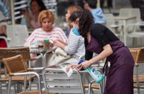 ep una trabajadora desinfecta las mesas y sillas de una terraza ep una trabajadora desinfecta las mesas y sillas de una terraza