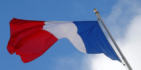 a french flag flutters in the sky over the elysee palace in paris