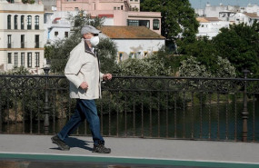 ep un hombre mayor pasea por el puente de triana en sevilla protegido con mascarilla