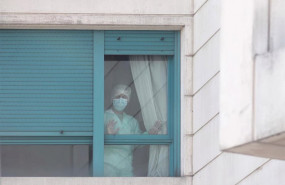 ep una trabajadora del personal sanitario protegida con mascarilla se asoma por una de las ventanas