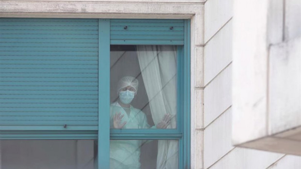 ep una trabajadora del personal sanitario protegida con mascarilla se asoma por una de las ventanas