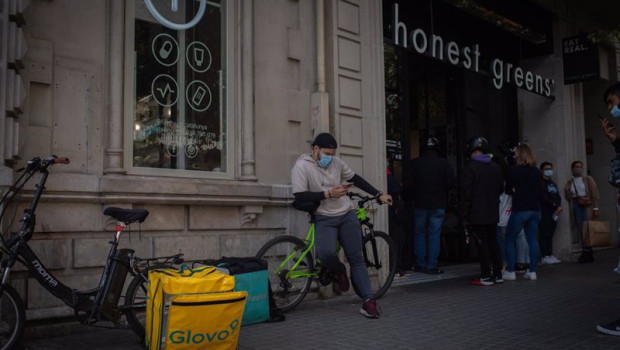 ep archivo   un trabajador de deliveroo descansa en su bicicleta