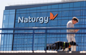 ep archivo   una persona camina frente a la sede de naturgy en madrid espana