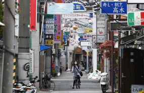 ep una mujer con mascarilla recorre en bicicleta una calle de tokio