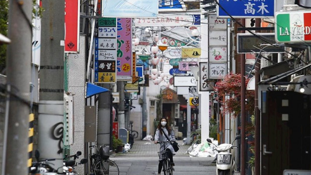 ep una mujer con mascarilla recorre en bicicleta una calle de tokio