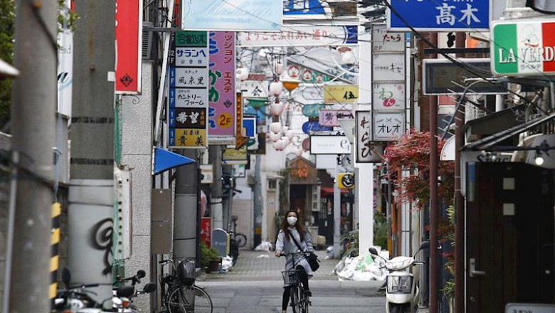 Una mujer con mascarilla recorre en bicicleta una calle de Tokio | James Matsumoto/SOPA Images via / DPA ep una mujer con mascarilla recorre en bicicleta una calle de tokio