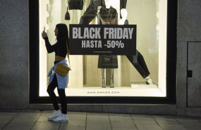 ep varias personas pasan por delante de los comercios que anuncian los descuentos del black friday a