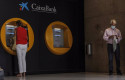 ep archivo   dos personas en los cajeros dispuestos en el edificio de la sede de caixabank en