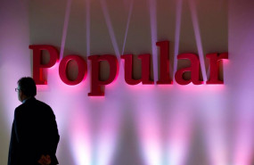 ep archivo   file photo a man stands next to the logo of spains banco popular during the banks