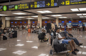 ep archivo   varias personas esperan sentadas con sus maletas en el aeropuerto josep tarradellas