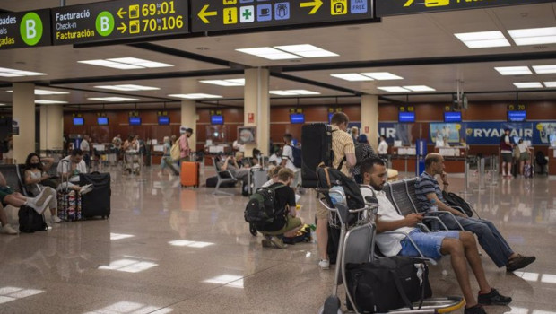 ep archivo   varias personas esperan sentadas con sus maletas en el aeropuerto josep tarradellas