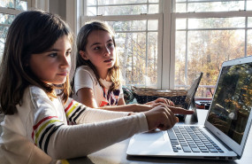 little girl pointing out a situation on her laptop that needs attention before she can finish her t20 e9ko2k 