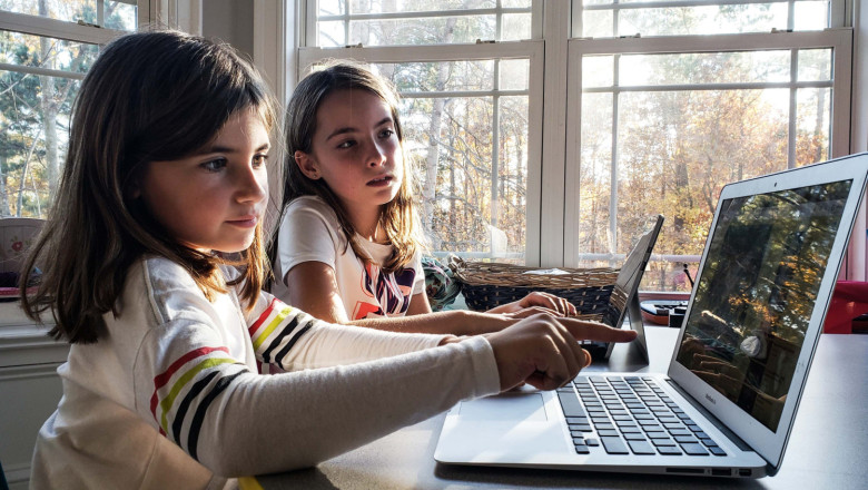 little girl pointing out a situation on her laptop that needs attention before she can finish her t20 e9ko2k 