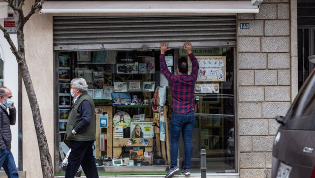ep archivo   un hombre levanta la cortina metalica de un comercio en badajoz extremadura espana a 29