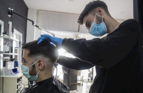 ep un peluquero atiende a un cliente en su peluqueria abierta durante el dia 51 del estado de alarma