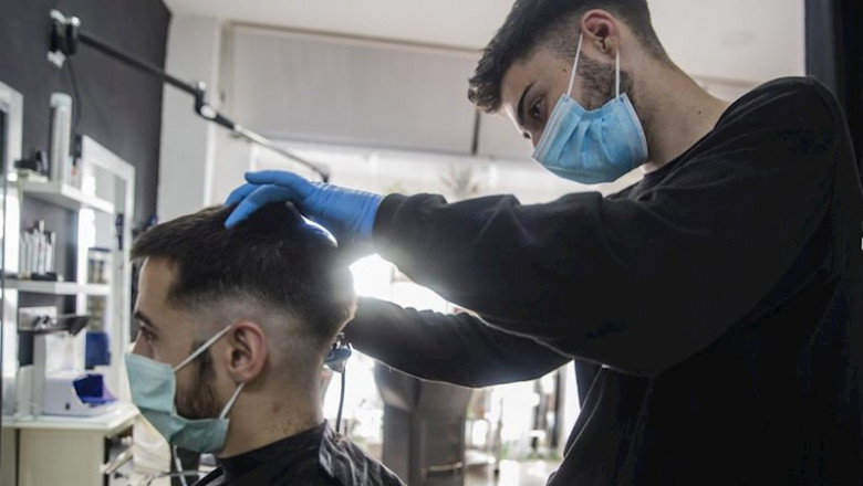 Un peluquero atiende a un cliente en su peluquería abierta durante el día 51 del estado de alarma, donde peluquerías y los salones de belleza abren por primera vez desde el estado de alarma este lunes 4 de mayo, con uso obligatorio de mascarillas, toallas | María José López - Europa Press ep un peluquero atiende a un cliente en su peluqueria abierta durante el dia 51 del estado de alarma