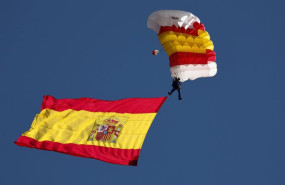ep archivo   la bandera de espana con uno de los miembros de la patrulla paracaidista del ejercito