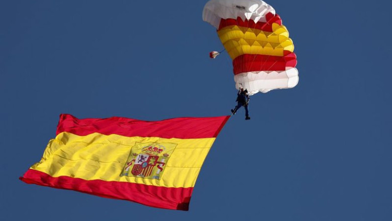 ep archivo   la bandera de espana con uno de los miembros de la patrulla paracaidista del ejercito