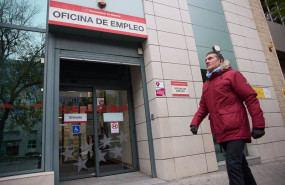 ep una persona camina frente a la entrada de la oficina de empleo